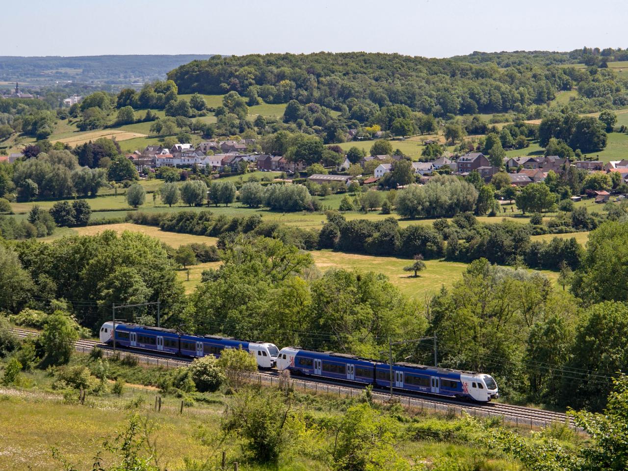 Een trein rijdt door het heuvelachtige landschap van Zuid-Limburg